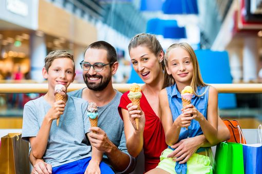 Family enjoying ice cream cones in public